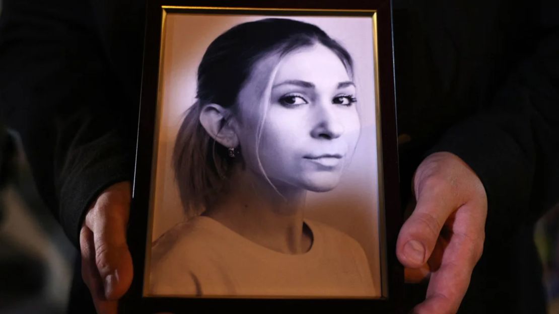 A colleague of Ukrainian journalist Victoria Roshchyna holds her photo during a memorial event in Kiev.